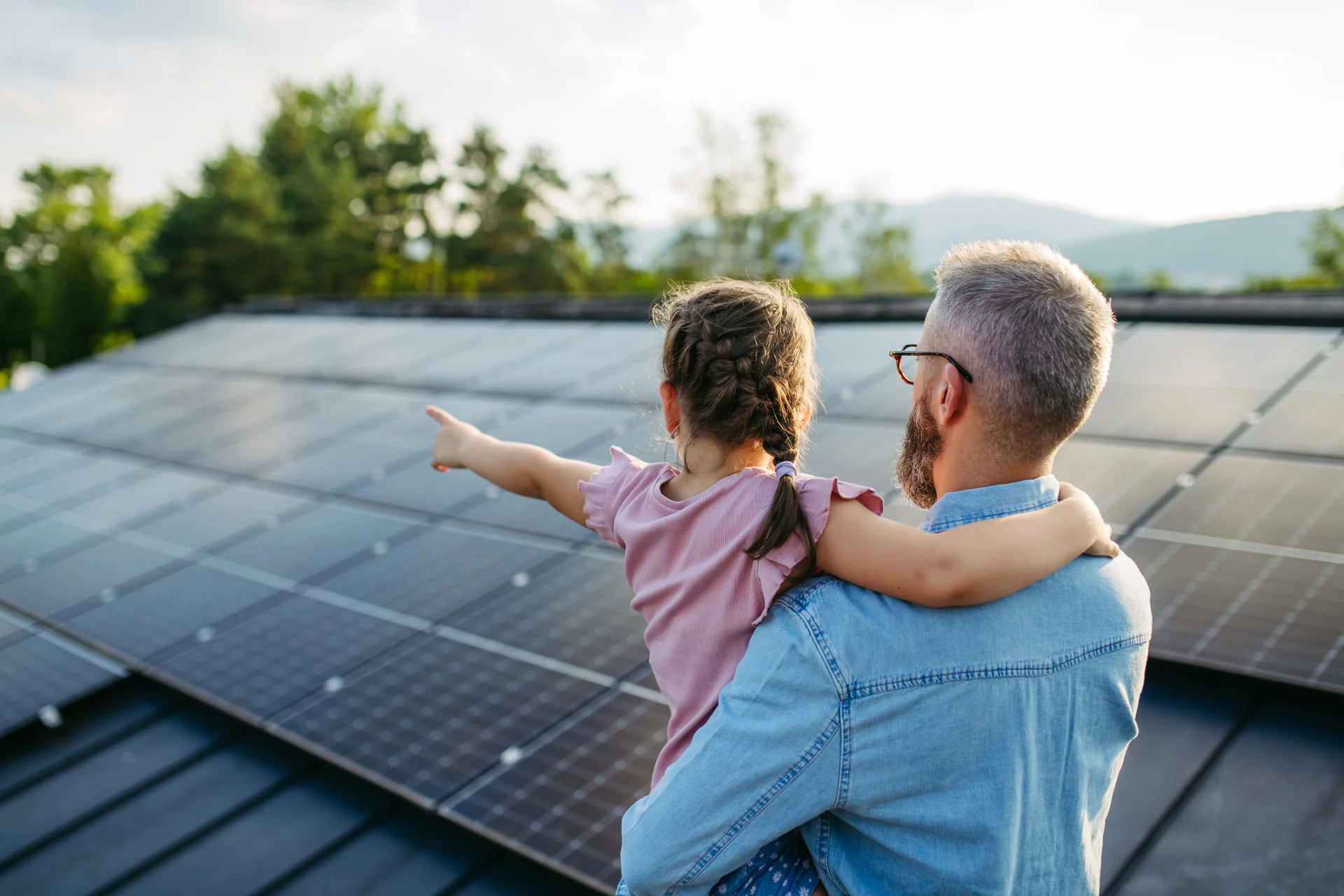 Father and daughter looking at rooftop solar panels